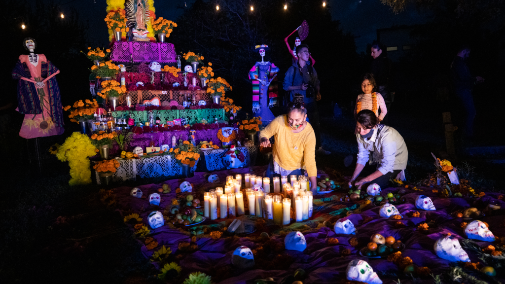 Kolorowy ołtarz Día de Muertos w Meksyku. Kwiaty, świece i symbole radosnej pamięci o bliskich.